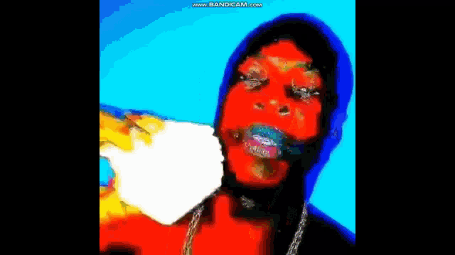 a man with a mask on his face is eating a hamburger and a french fries .