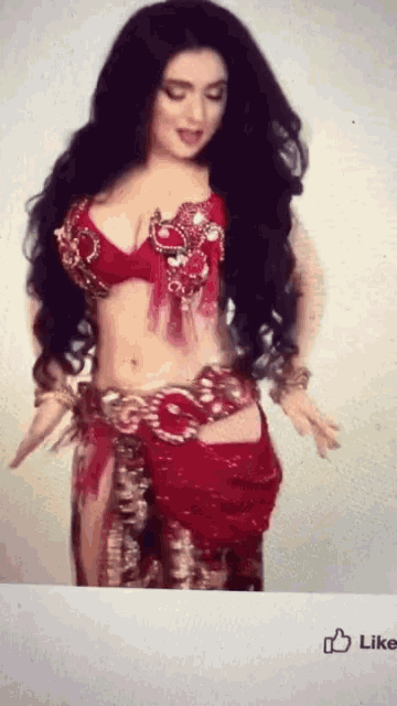 a belly dancer in a red outfit has a like button below her