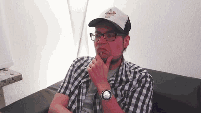 a man wearing a plaid shirt and a white hat with a monkey on it