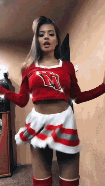 a woman in a cheerleader costume with the letter m on her top