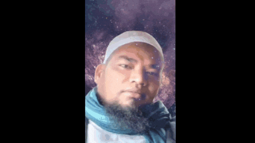 a man with a beard wearing a white hat and blue scarf .