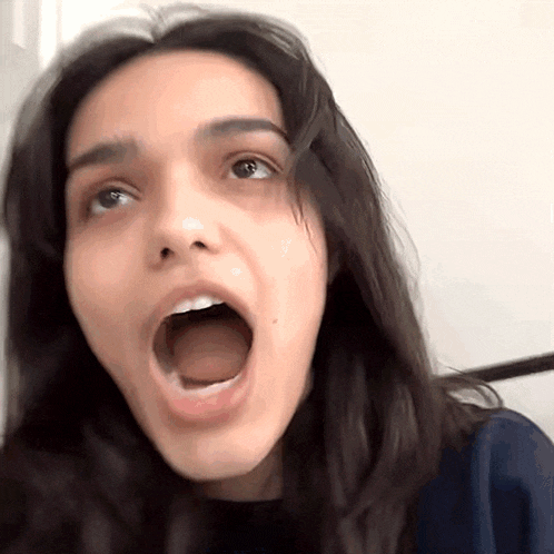a woman is making a funny face with her mouth wide open