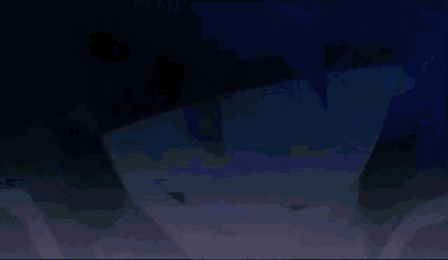 a silhouette of a person in a dark room with a blue background