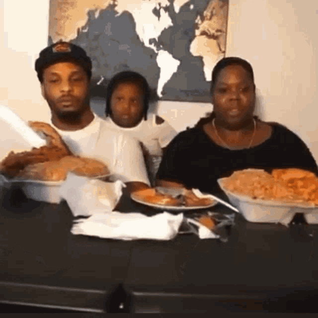 a group of people sitting at a table with plates of food
