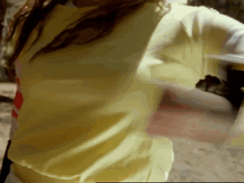 a woman is wearing a yellow shirt with a red stripe on the sleeves