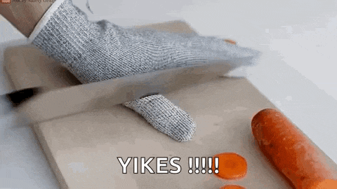 a person wearing a glove is cutting carrots on a cutting board .