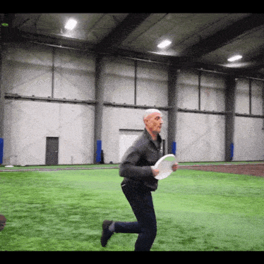 a man is running with a frisbee in his hands