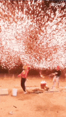 a man in a red shirt stands in front of a firework display
