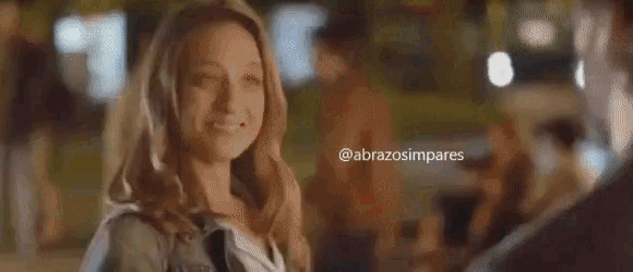 a woman is smiling while looking at a man .