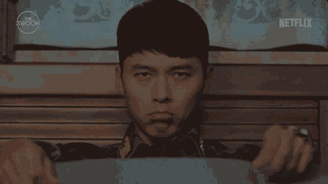 a man is sitting in a chair with his eyes closed and a netflix logo behind him