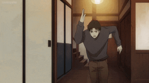 a man in a black sweater stands in a hallway with the word animepahe on the bottom left