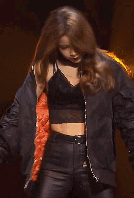 a woman in a black jacket is holding a microphone in her hand