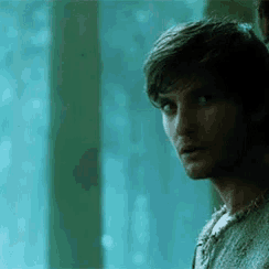 a man is standing in front of a window with his eyes closed .