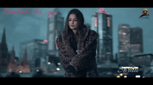 a woman in a fur coat is in front of a city skyline