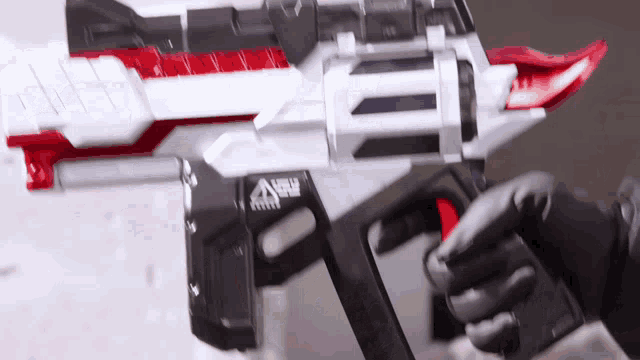 a person is holding a toy gun with a new logo on it