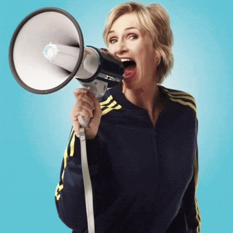 a woman is holding a megaphone with her mouth wide open