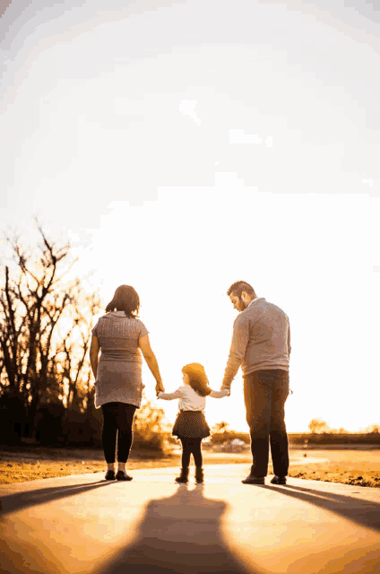 a family walking down a path holding hands