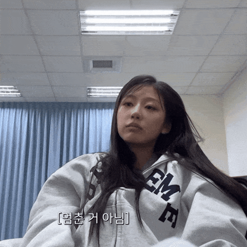 a woman wearing a sweatshirt that says em on the front
