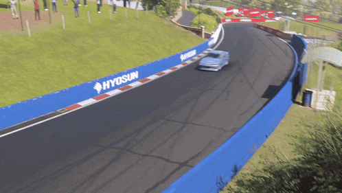 a car is driving on a race track with a hyosun banner