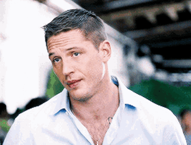a close up of a man 's face with a blue shirt on