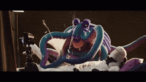 a stuffed octopus with purple tentacles is being filmed by a camera