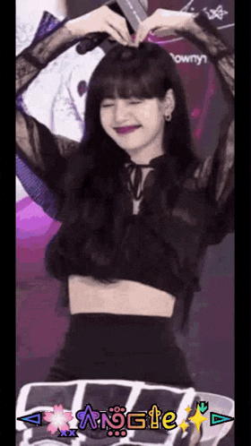 a woman in a black crop top is making a heart with her hands .