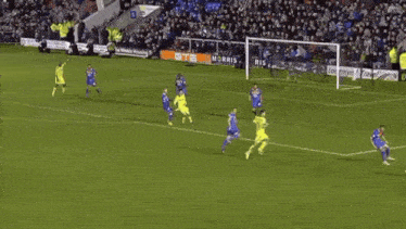 a soccer game is being played on a field with a coral advertisement in the stands