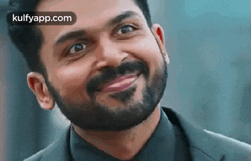 a man with a beard is smiling and looking up .