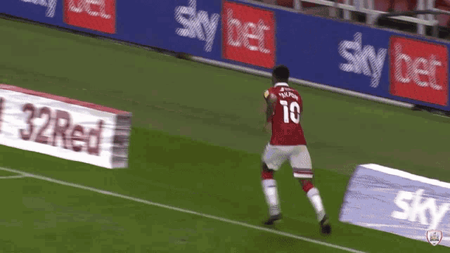 a soccer player with the number 10 on his jersey is kneeling on the field