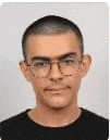 a young man wearing glasses and a black shirt is smiling for the camera .