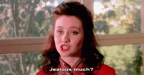 a woman in a red dress is sitting in front of a window and says `` jealous much '' .