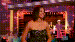 a woman in a strapless dress is smiling on a stage