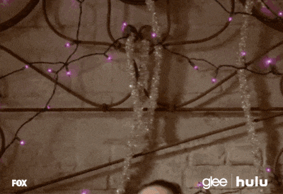 a woman is laying on a bed with purple lights behind her and the words glee hulu are on the bottom