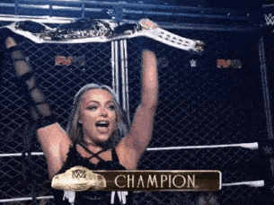 a woman in a wrestling ring is holding up a champion 's belt