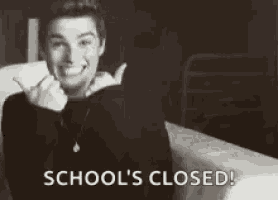 a black and white photo of a man sitting on a bed smiling and saying `` school 's closed ! ''