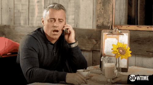 a man sitting at a table talking on a phone with showtime written on the bottom