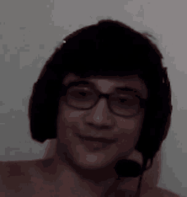 a man wearing glasses and headphones with a microphone .