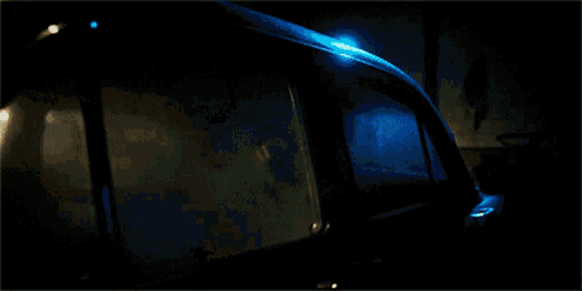 a person 's hand is visible through the window of a dark car