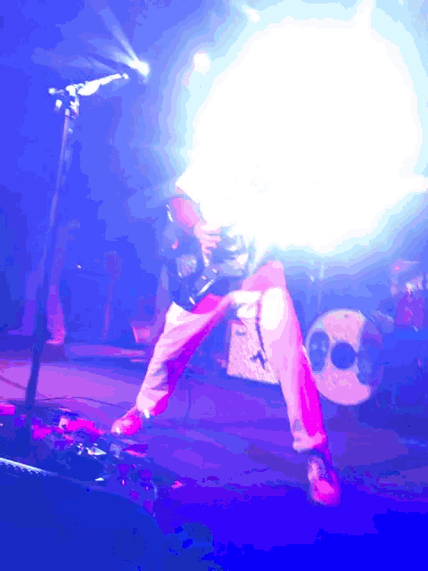 a man is playing a guitar in front of a drum set