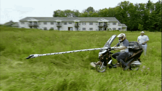 a man is riding a motorcycle with a long pole attached to the windshield