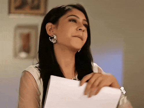 a woman holding a piece of paper in her hand