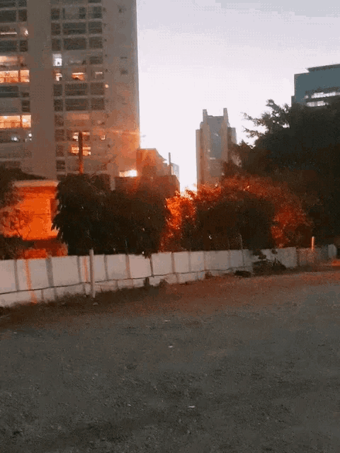 a fenced in area with a building in the background at night