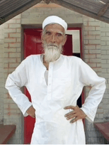 a man with a beard and a white hat is standing with his hands on his hips in front of a red door