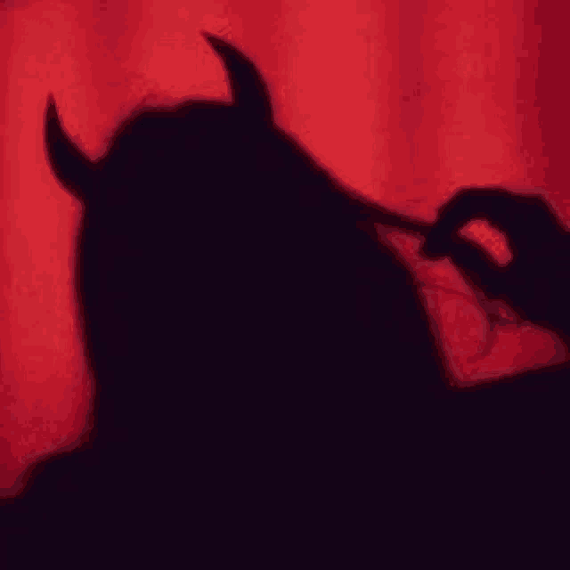 a shadow of a woman with horns on her head .