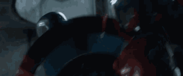 a close up of a man in a superhero costume fighting another man .