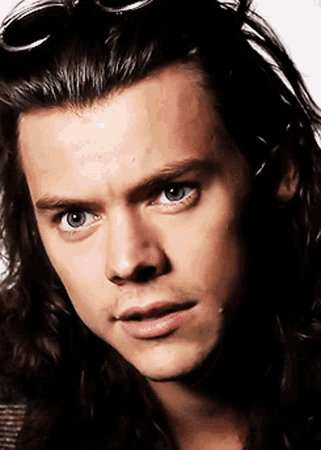 a close up of a man 's face with long hair and sunglasses on