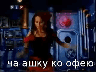 a woman in a black dress is dancing in a dark room with a ptp logo in the background