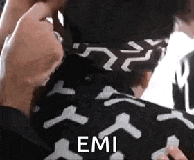 a close up of a person wearing a black and white shirt with the word emi written on it .