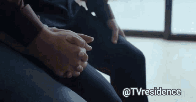 a couple sitting on a couch with their hands folded in front of a window with the words @tvresidence above them