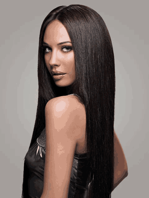 a woman with very long dark hair is wearing a black dress
